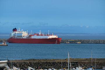 LNG carrier moored by pier in port on hazy evening. 