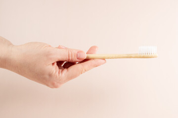Eco toothbrushes in hand, wooden dental brushes for natural oral care