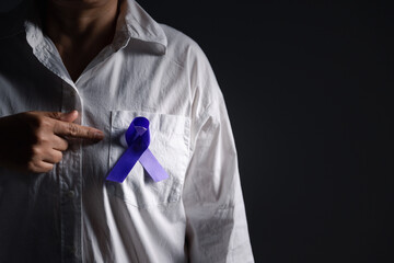 Woman with purple ribbon on grey background, closeup with space for text. Domestic violence...