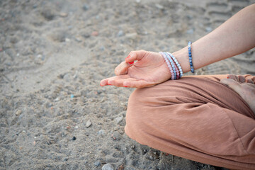 Close-Up of a Girl's Hand While in Lotus Pose on the Beach