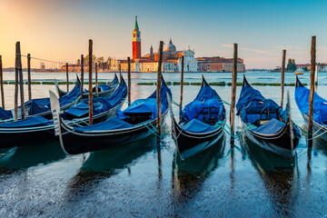 Gondolas and San Giorgio Maggiore Island at sunrise, Venice, Italy.  Romantic walk in Venice at sunrise with view of the basilica di Giorgio Maggiore. © Pi-R