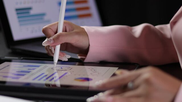 Businesswoman analyzes statistical financial data on a tablet. Business and investment data analysis.