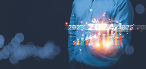 Businessman holding growth graph virtual screen with year 2024 on hand with copy space. The future...