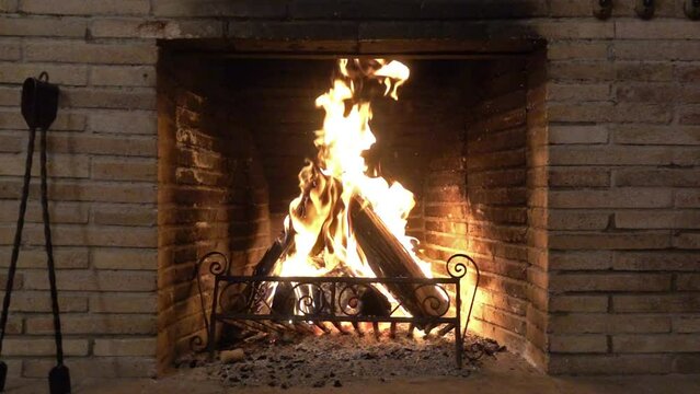 Fireplace flames wood fire burning and old charred bricks.
