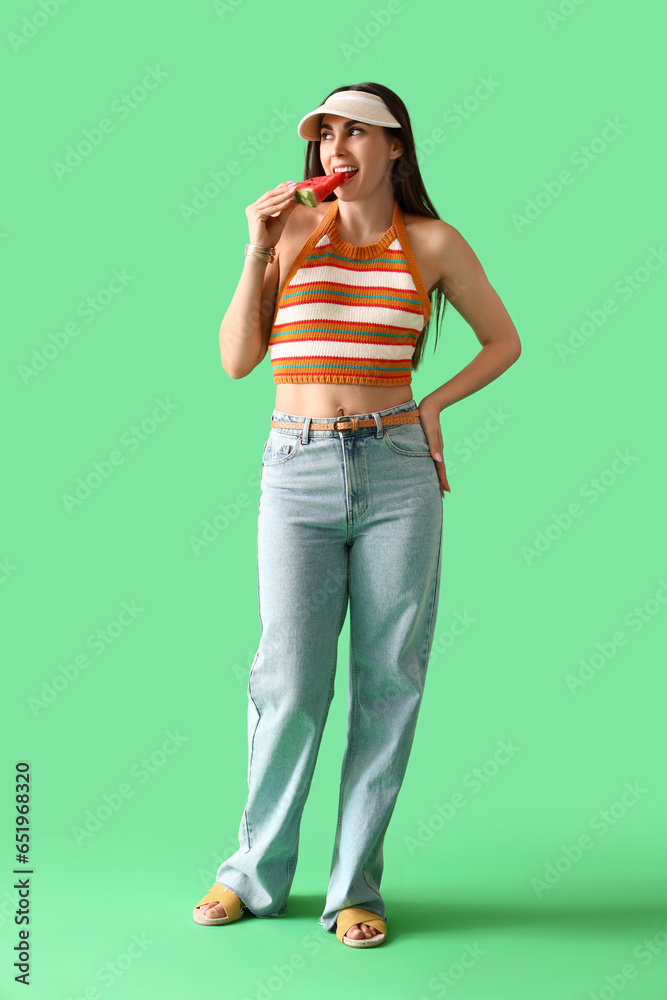 Sticker Young woman eating fresh watermelon on green background