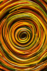 Close up view of a spiral colorful vegetarian tart made of lengthwise vegetable slices, before baking