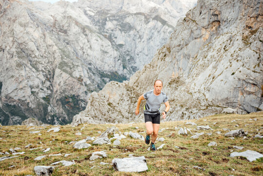 Sportsman running on mountain environment wearing sportswear - Powered by Adobe