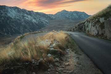 Winding Road To The Durmitor. 
A winding road leads to the Durmitor Mountain Range at sunset in Durmitor  National Park, Montenegro