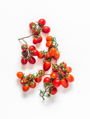 Fresh ripe cherry tomatoes on twigs on a white background, top view