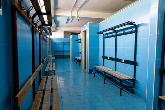 changing rooms of a swimming pool with light blue tiles geometric view of benches, doors and showers