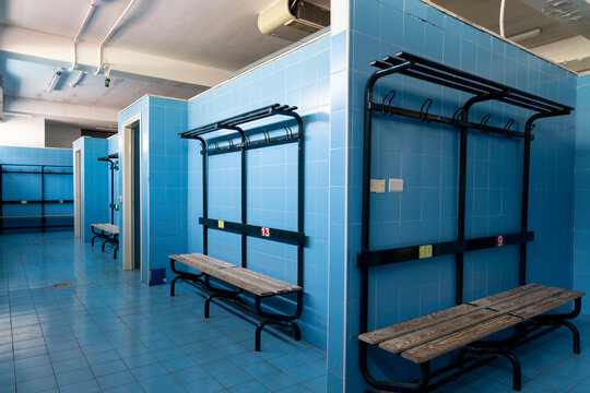 changing rooms of a swimming pool with light blue tiles geometric view of benches, doors and showers