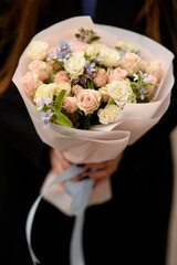 Close up view of beautiful tender various flowers bouquet in woman's hands.