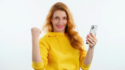 Surprised young woman pointing at mobile phone. Wow! Lady amazed excited with smartphone for social media, online streaming, news and internet, surprise face. Studio shot isolated on white background