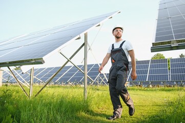 A handyman standing with solar panels.