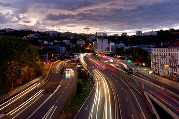 Fototapeta na wymiar Panoramic photo of the exit of the Fourvière tunnel and the traffic of cars circulating there in Lyon, France at dusk in september 2024.