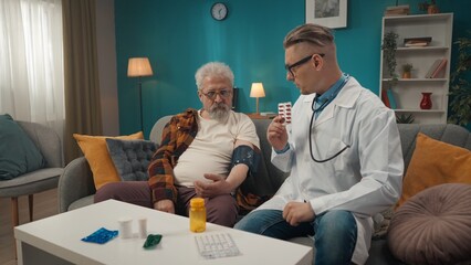 Full-size shot of a doctor checking up the condition of his patient at home. He is using sphygmomanometer, a device for measuring blood pressure.