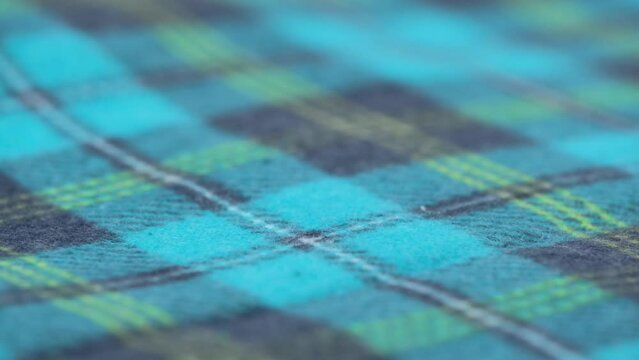 cozy flannel fabric with a blue checkered pattern. closeup. slow rotation of soft cotton fabric. macro. fabric background textile production.