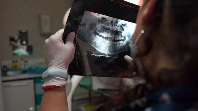 dentist checking an x-ray of a patient's mouth