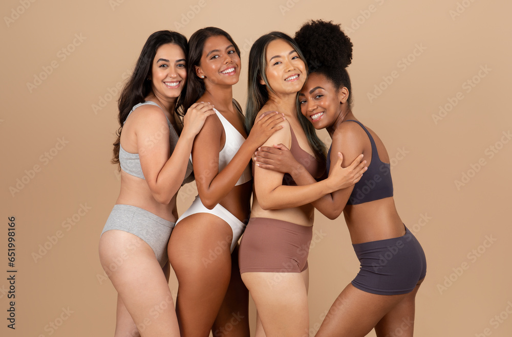 Wall mural Happy young diverse women in different underwear, body types, posing and enjoying natural beauty, beige background - Wall murals