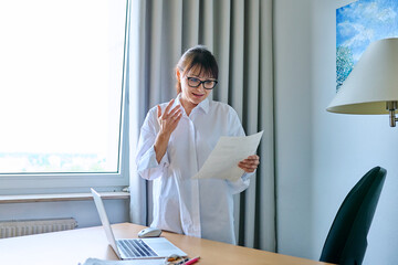 Middle aged businesswoman reading business official paper letter document