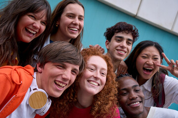 Selfie of smiling multi-ethnic group of college students together outdoors. Joyful young...