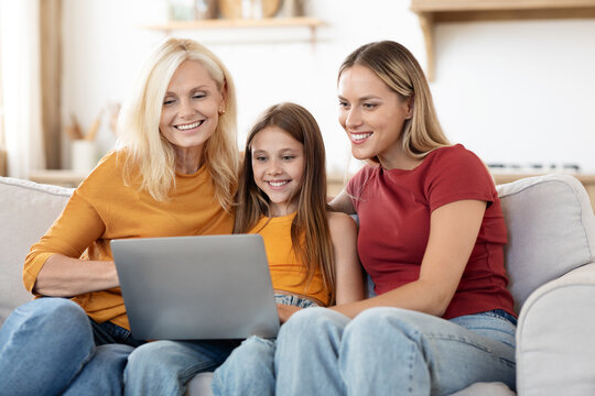 Beautiful family mother, grandmother, daughter watching movie on laptop