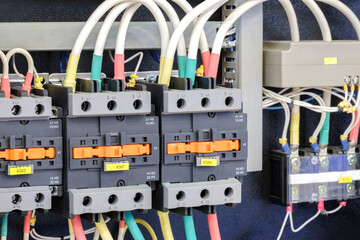 Close-up of Electricity distribution box with wires and circuit breakers in control room.