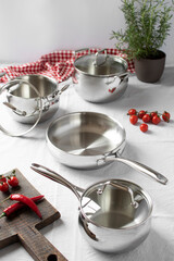 Set of stainless pots with lids and vegetables