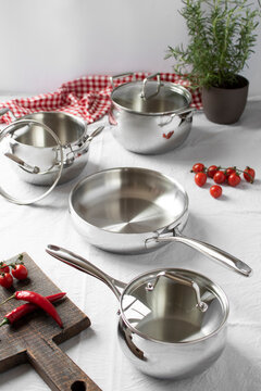 Set of stainless pots with lids and vegetables