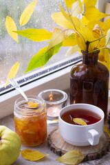 Cup of tea and bouquet of autumn leaves on window sill