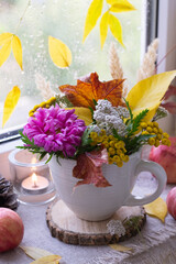 Bouquet of autumn flowers on window sill