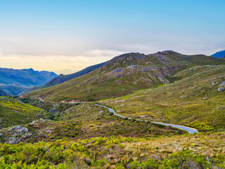 Fototapeta na wymiar Winding road though Hottentots-Holland Mountain at sunset during spring, Western Cape, South Africa
