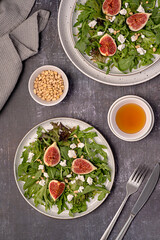 Food photography of salad; goat cheese; fig; feta; leaf; lettuce; rocket; pine; nut; honey