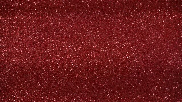 Red glitter abstract background with sparkling texture, shimmering light, sparks and glittering glow 