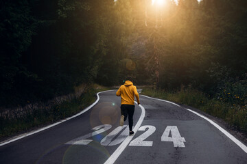 Man running on the mountain road towards new goals in 2024. New Year 2024 with new ambitions,...