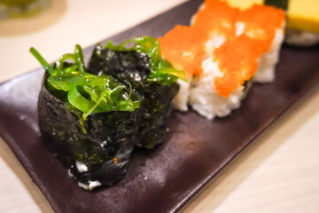 Various sushi platter in square ceramic plate on Japanese Restaurant. Concept for whole healthy food, nutrition, omega-3, animal protein, seafood, modern resto and street food. 