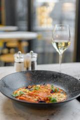 Salmon tataki in sauce with peanuts and herbs on a marble table in a restaurant