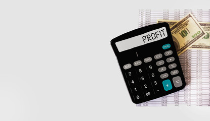 Calculator with the word PROFIT on a white background with dollars. Business, finance, marketing