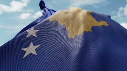 Wavy flag of Kosovo blowing in the wind in slow motion. Waving official Kosovo flag team symbol abstract vertical background. Blue sky with clouds. World countries flying flags concept