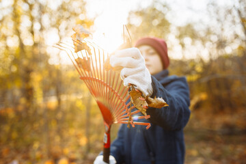 A close-up shot of a young guy wearing gloves adjusting a rake. Volunteer in the park. Cleaning...