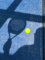Sombra de raqueta y pelota de paddle tenis en una cancha