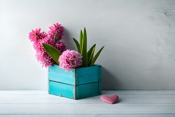 Fresh pink hyacinth flowers in a wooden box with a decorative heart against a white wall. The background is painted