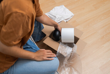 home decor aficionado inspects her parcel, affirming happiness through e-commerce and expedited...