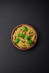 Obraz na płótnie Canvas Delicious fresh pasta with green pesto sauce with basil