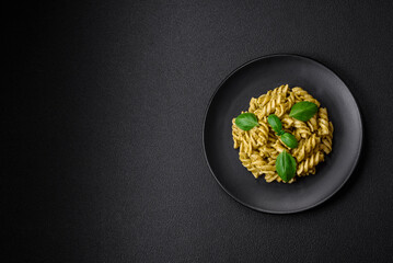 Delicious fresh pasta with green pesto sauce with basil