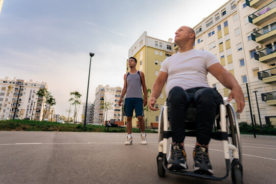 a picture of a black man and a white man in a wheelchair playing basketball