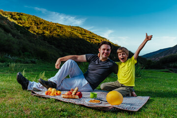 Happy father and son on picnic in the mountains