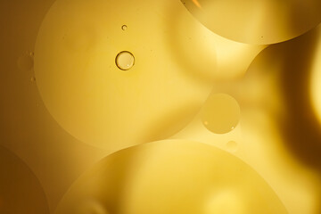 Yellow oil bubbles on water, cooking oil background.