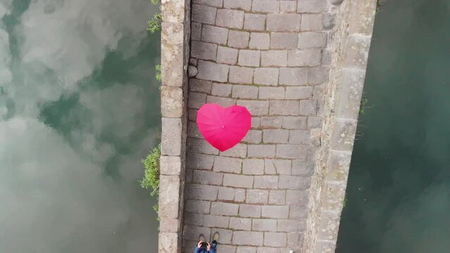 Aerial overhead view of Devils Bridge, Lucca. Red heart shape umbrella on the bridge