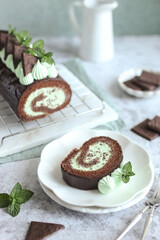 Chocolate Mint Cake Roll. Delicious homemade dessert. Fresh mint leaves, green napkin and white plate.
